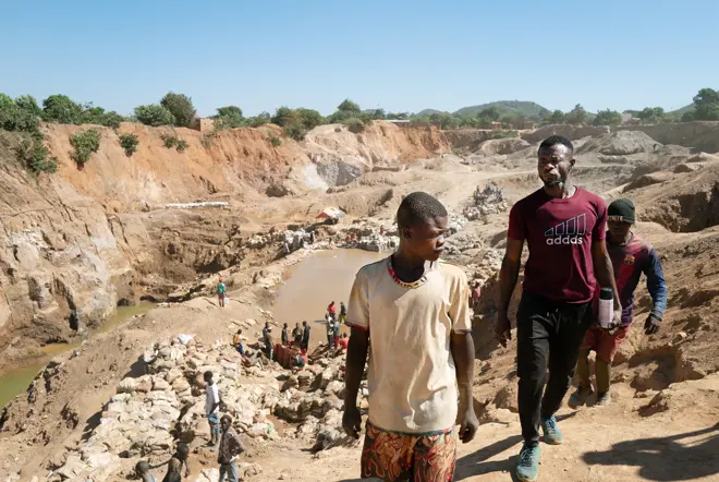 Three men walking through the desert.