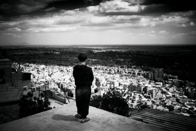 A boy overlooking a city