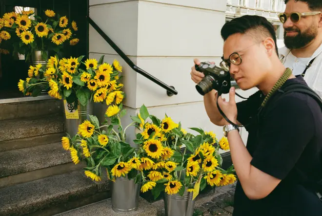 A person is taking a photo with a Leica camera