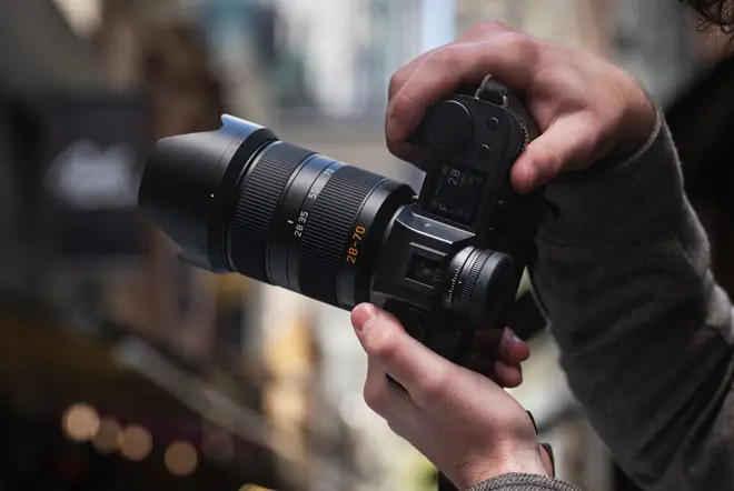 A person is taking photographs with the Leica SL camera