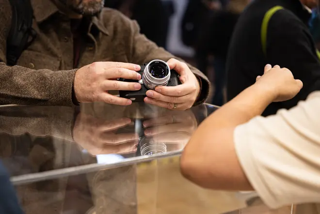 Homme appareil photo à la main qui échange avec un vendeur sur un stand