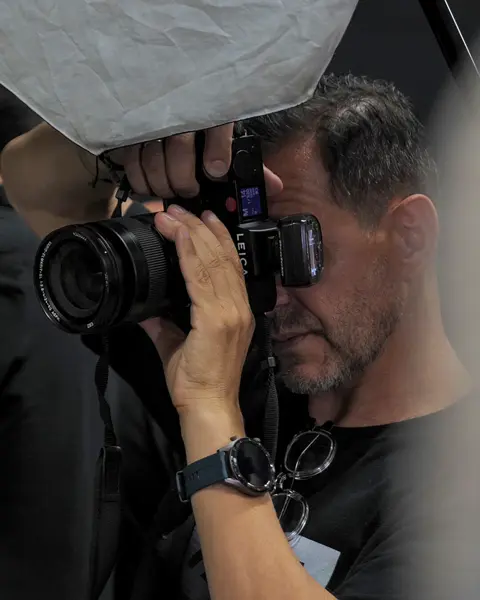 Close-up of a man taking a picture in a studio.