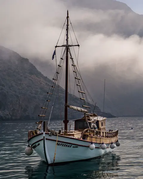 A sailing ship on the sea in front of an island