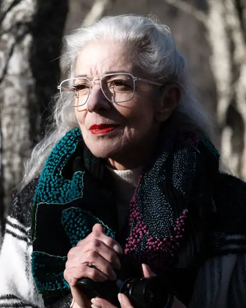 an elderly woman wearing glasses with Leica lenses