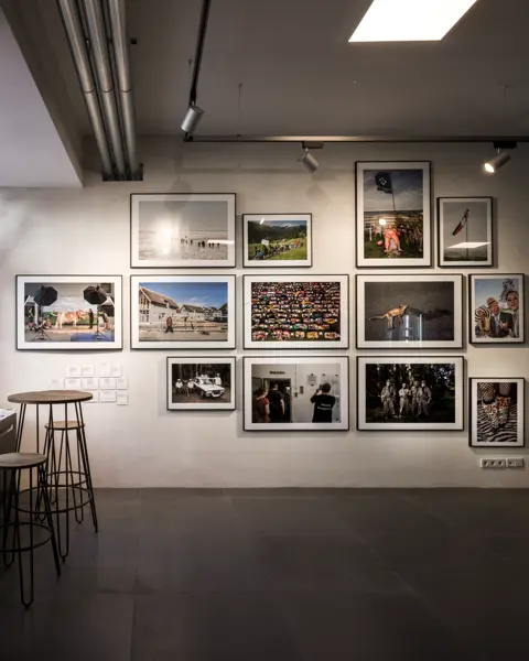View of a wall with framed photos of people and animals.