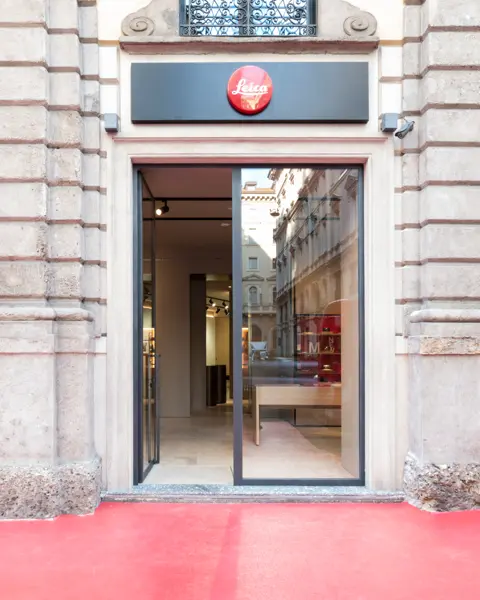 Entrance to a Leica Gallery with glass front and red Leica logo on a sign.