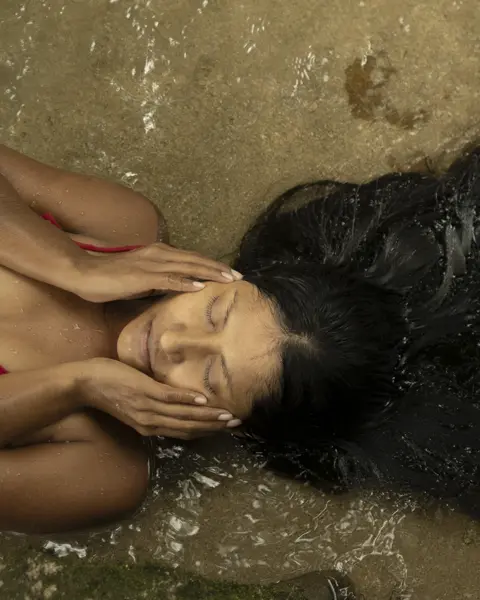Woman with long brown hair laying in the sea