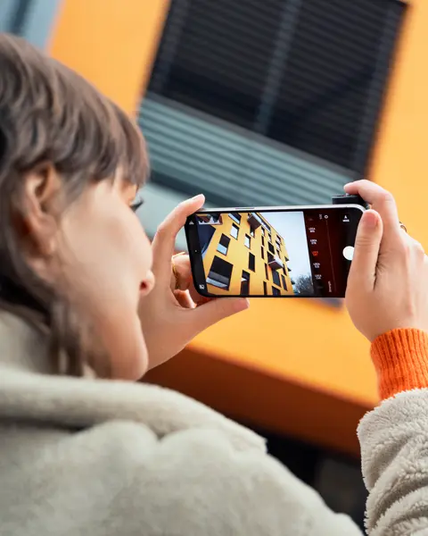 Woman photographing with the Leica LUX Grip