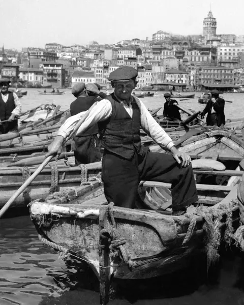 Many men on their boats in the harbour in the 30s