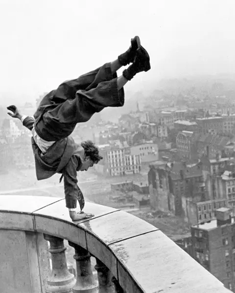 Man doing a handstand on a high banister