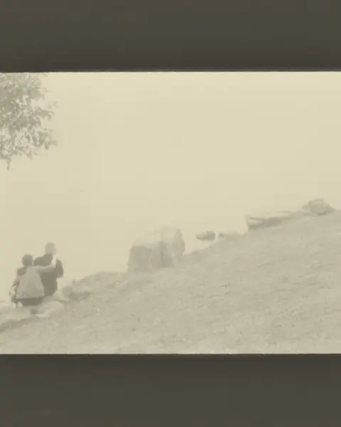 couple sitting hugging on large stones