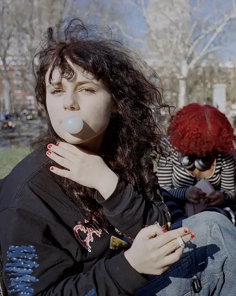 Teenage girl with chewing gum bubble