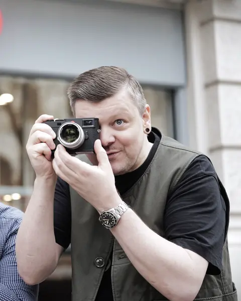 Two sales associates standing infront the Leica Store Berlin and taking pictures with Leica Cameras