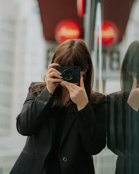 One sales associate standing infront the Leica Store Frankfurt and taking pictures with a Leica M