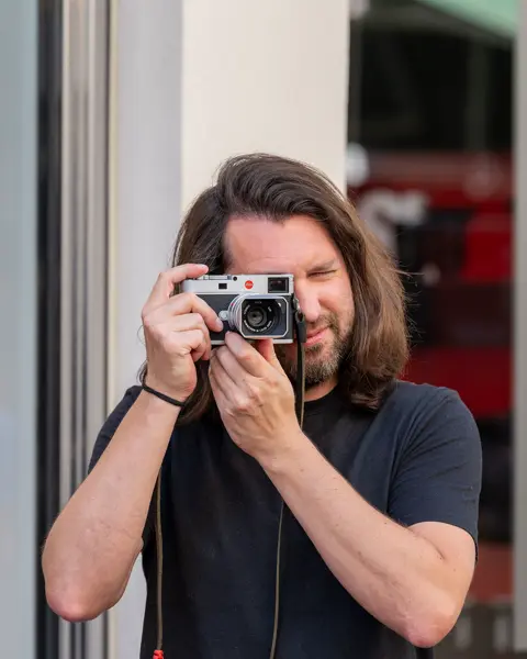 One sales associate standing infront the Leica Store Stuttgart and taking pictures with a Leica M