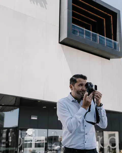 Store Manager of the Leica Store Wetzlar Leitz-Park standing in front of the store and taking pictures with a Leica M