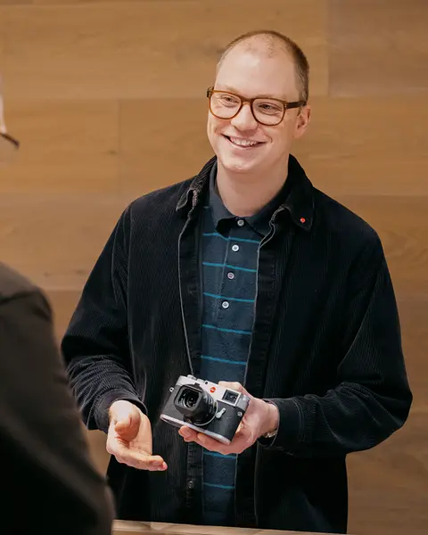 Leica Expert showing a Leica camera and explaining something