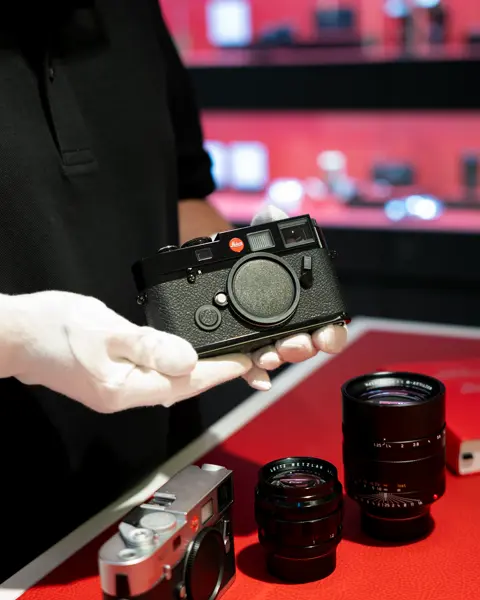 Close-up from a Pre-Owned Leica, held in gloves