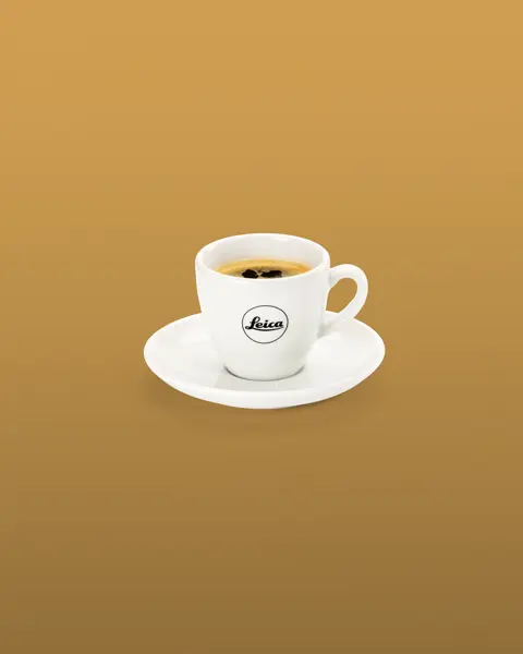 White espresso cup with saucier and Leica logo.