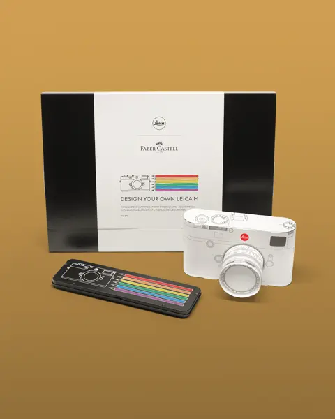 Faber Castell pencil box with white paper camera in front and pens beside.