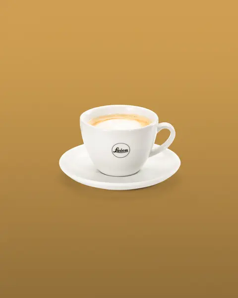 White coffee cup with saucer and black Leica log on the cup.