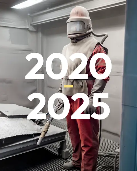 Man in a full-body protective suit in a room with a hose in his hand