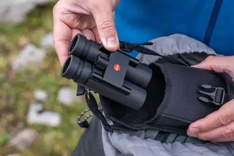 Man pulls his Leica Noctivid Compact out of the pocket