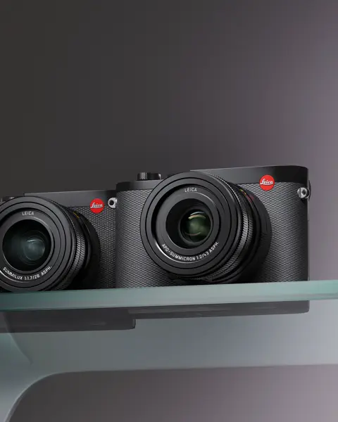 Two compact cameras on a glass table