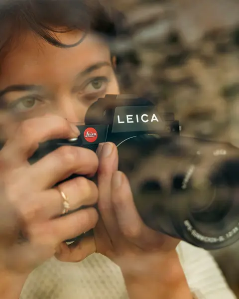 Woman photographing with the SL3 and APO-Summicron 35