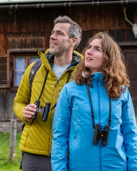 Two hikers in the mountains with their Leica Noctivid Compact