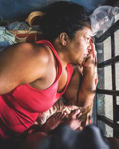 A woman is lying down and looking into the distance