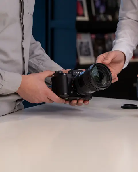 Customer exploring Leica Trade-In options while testing a Leica SL-System camera with a Leica expert.