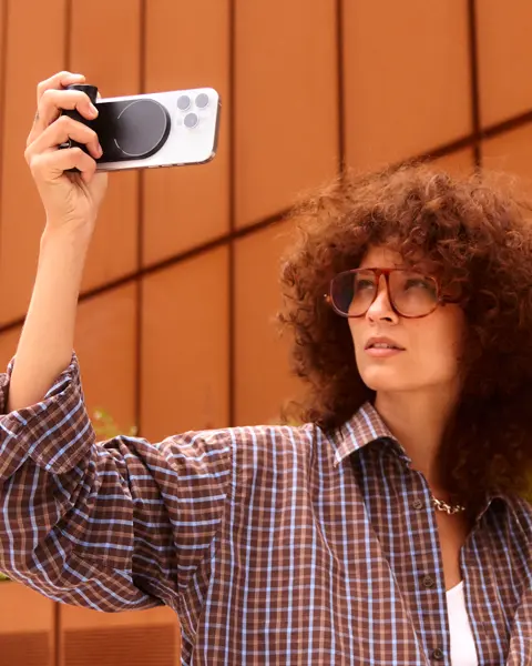 Woman with curly hair using the Leica LUX Grip