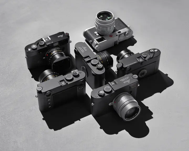 Top view of several Leica cameras on a gray background