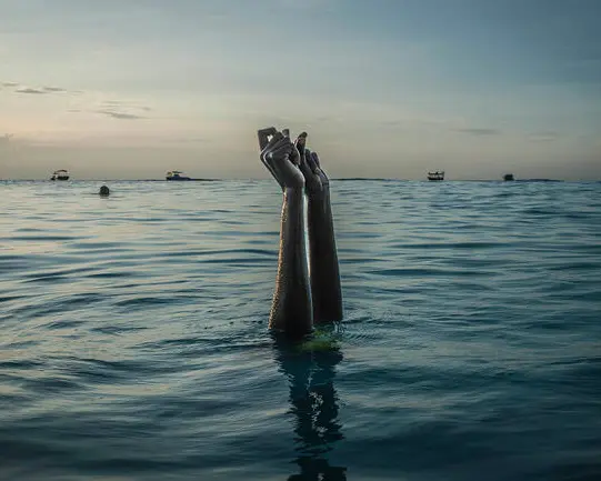 Women's arms peek out of the sea