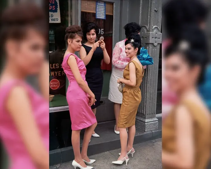 Four women standing in front of a shop with big windows.