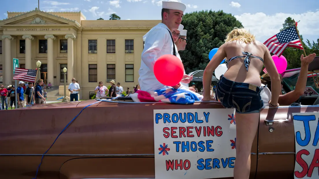 Woman gets into a convertible with sailors in America