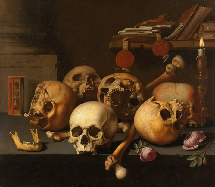 Vanitas still life with multiple human skulls and bones, an hourglass, documents, seals, flowers and a burning candle arranged on a dark table.