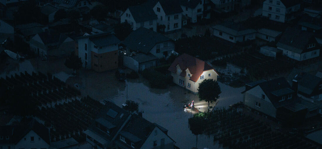 Night shot of a flooded city and rescue workers are in focus.