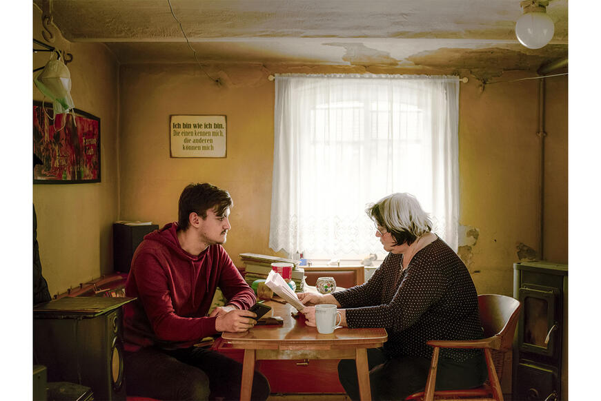 A young man with his grandmother at home at their table