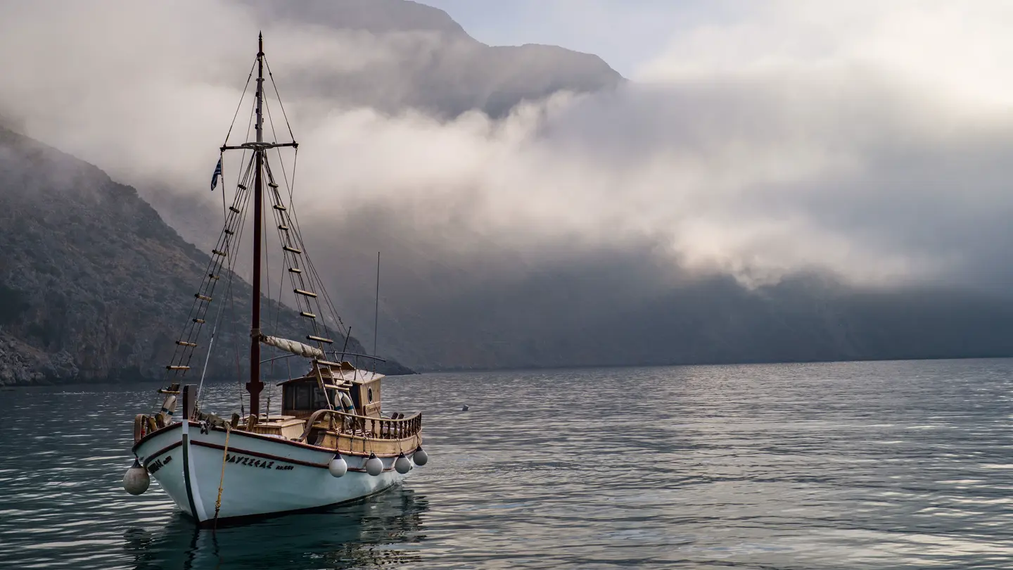 A sailing ship on the sea in front of an island