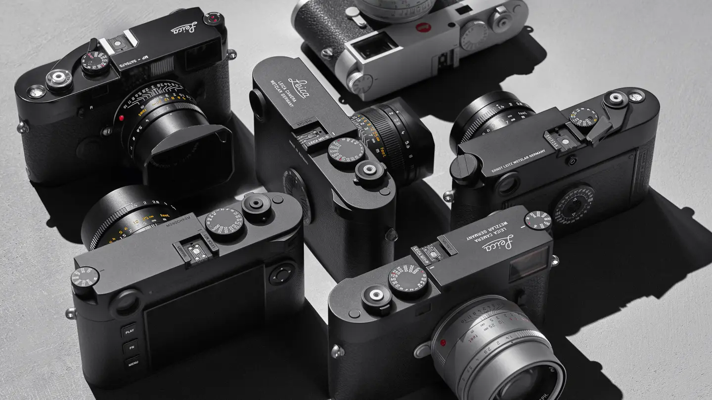 Top view of several Leica cameras on a gray background