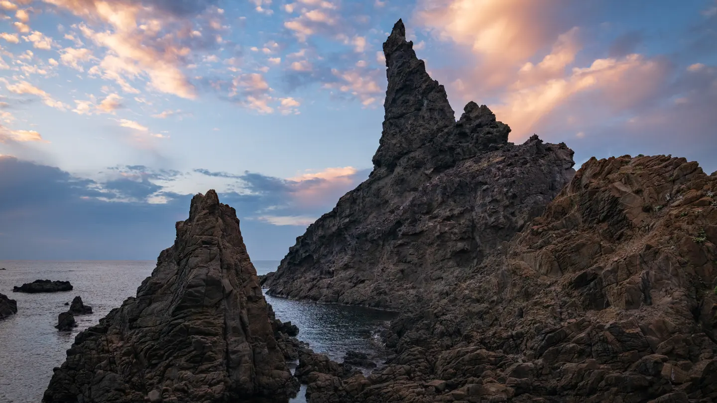 Majestic island: Nishinoshima, sky painted in sunset hues, tranquil sea, gently embracing the fading light.