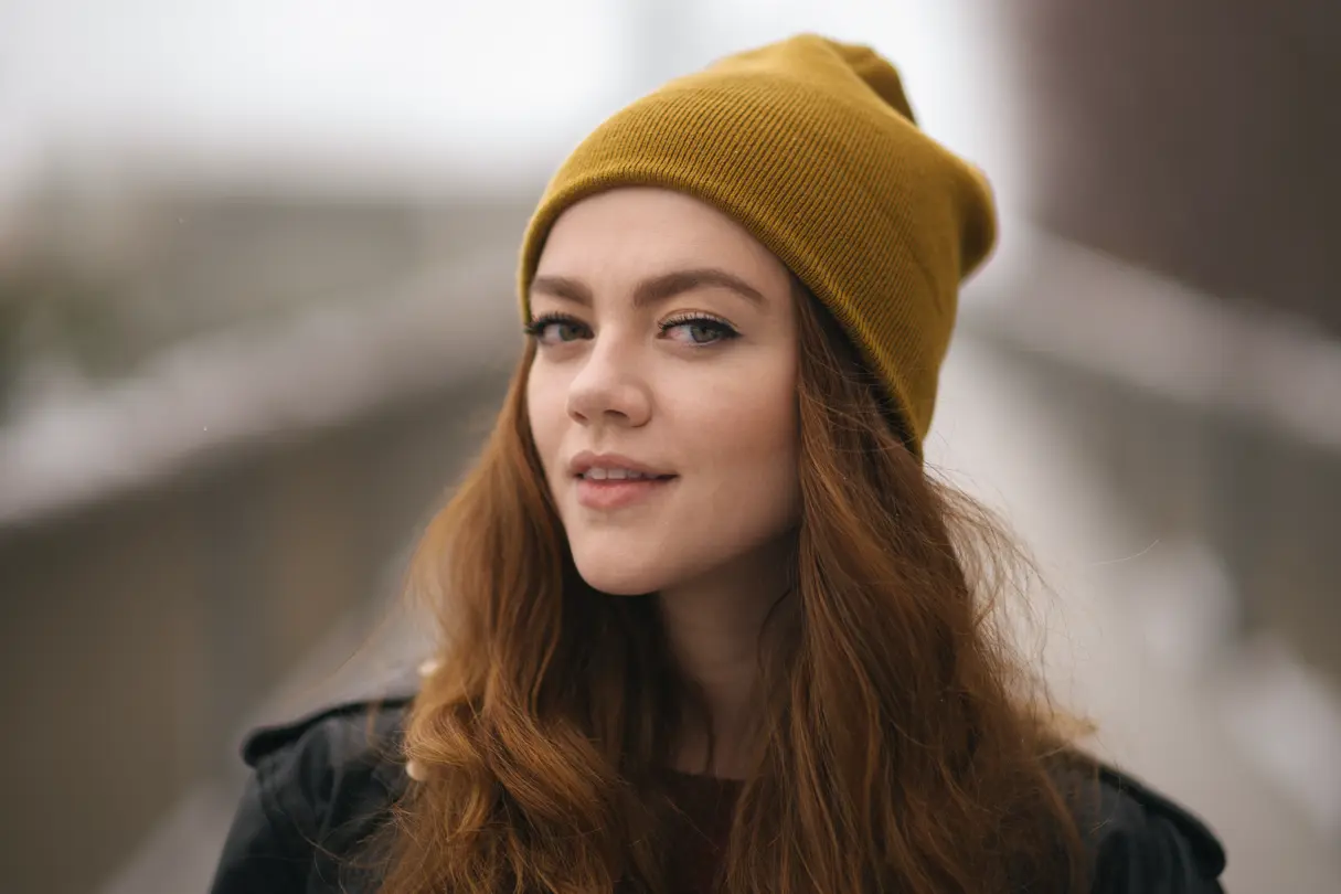 Woman with brown hair and a hut