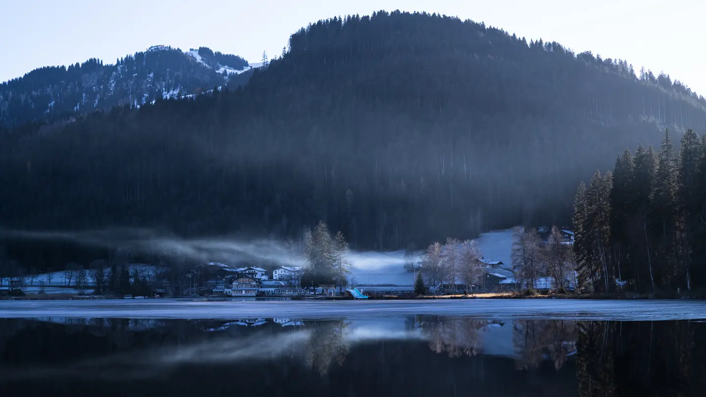 Houses by the lake surrounded by fog and snow and ice