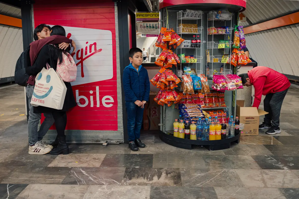 Colour photo of a small street shop with a young couple, a boy and a man