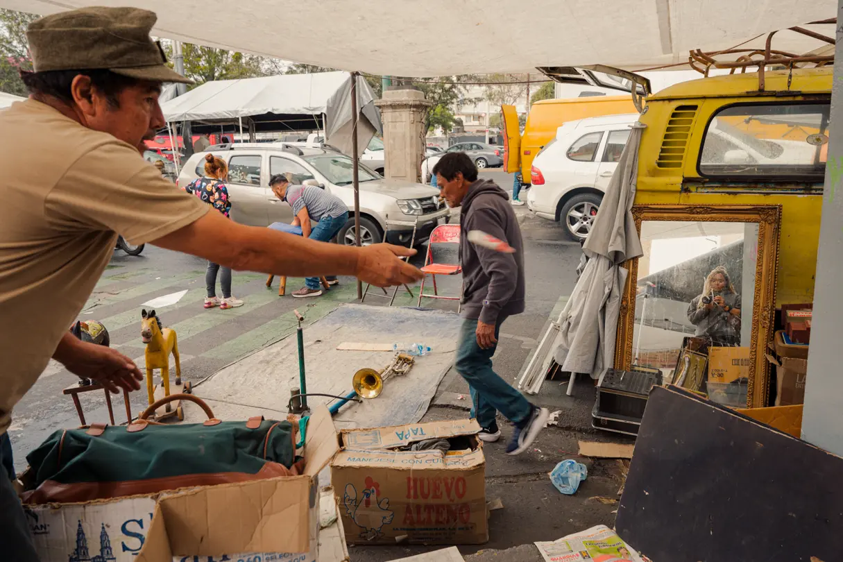 Colour street photograph of a street stall and Holly reflected on a mirror
