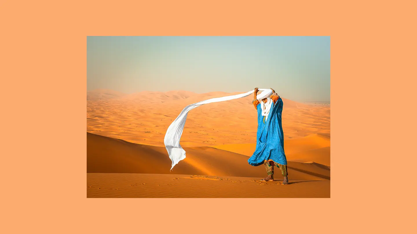 Man with blue robe and white turban in the desert