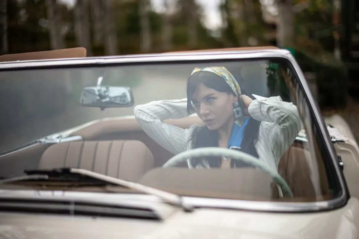 woman with brown long hairs in a oldtimer cabrio