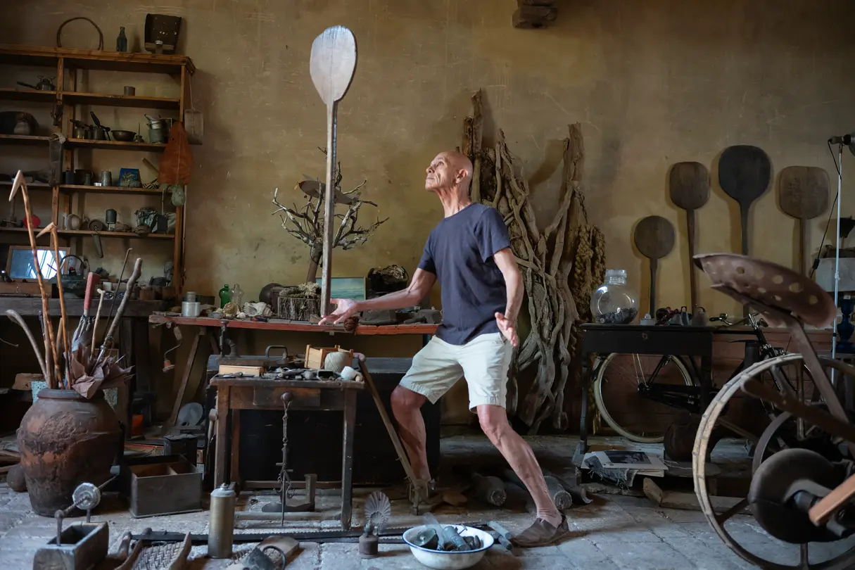 Man juggling a stick in his workshop